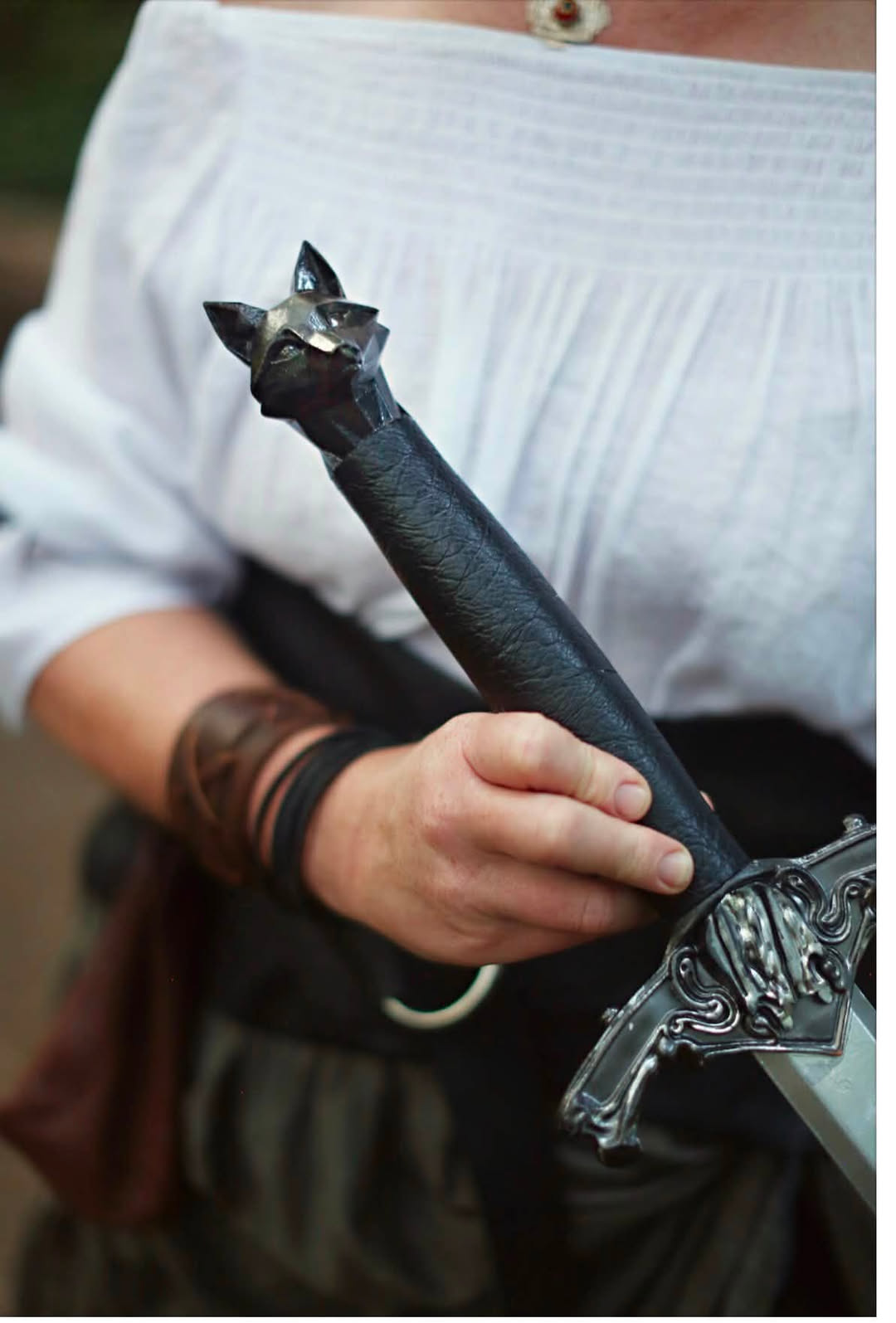 A hero sword with a beast head pommel and scrollwork guard.
